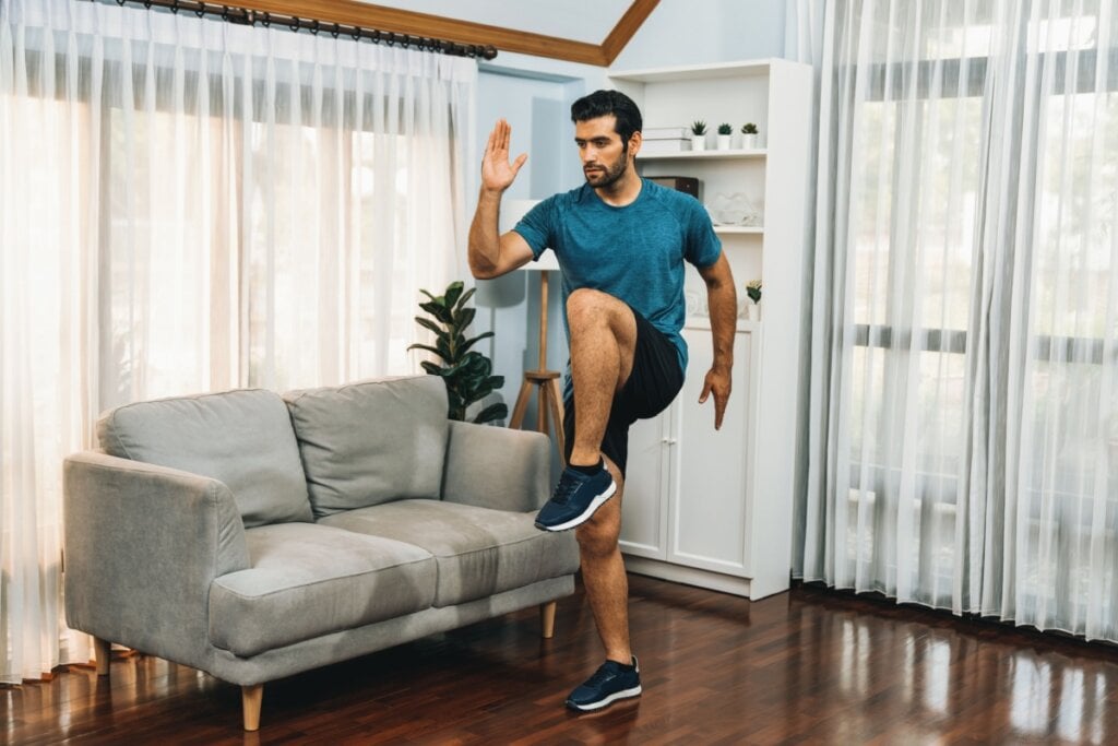 Homem fazendo o exercício skipping em casa