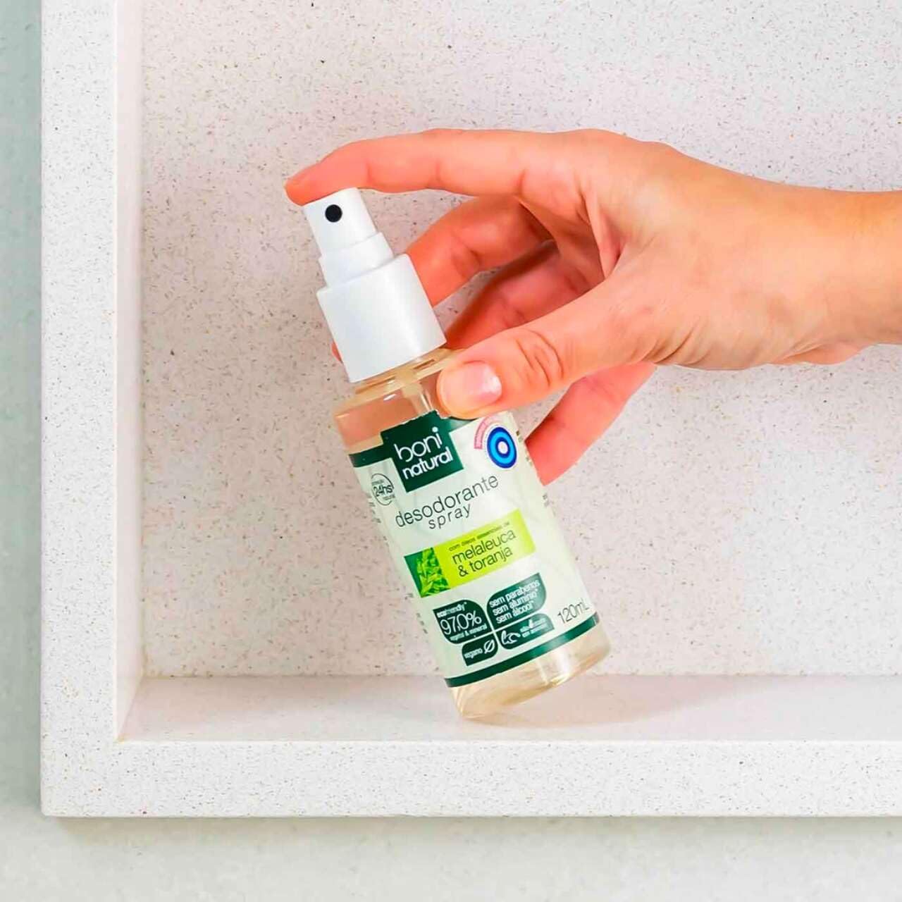 Imagem frontal do produto com fundo branco texturizado, com um nicho ou moldura branca ao redor.