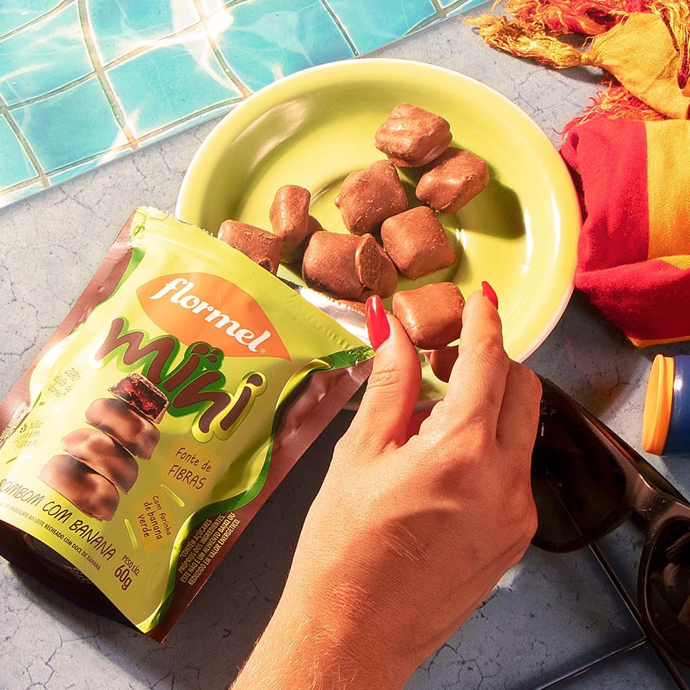 Visão superior da embalagem sobre superfície azul clara, com parte de uma piscina e itens de lazer ao redor.