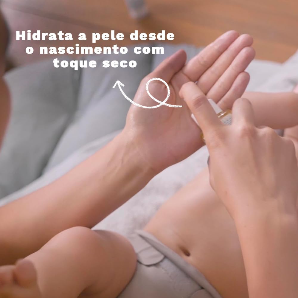 Close-up do bebê com fundo desfocado em tons claros, ambiente interno com piso de madeira e tecido claro.