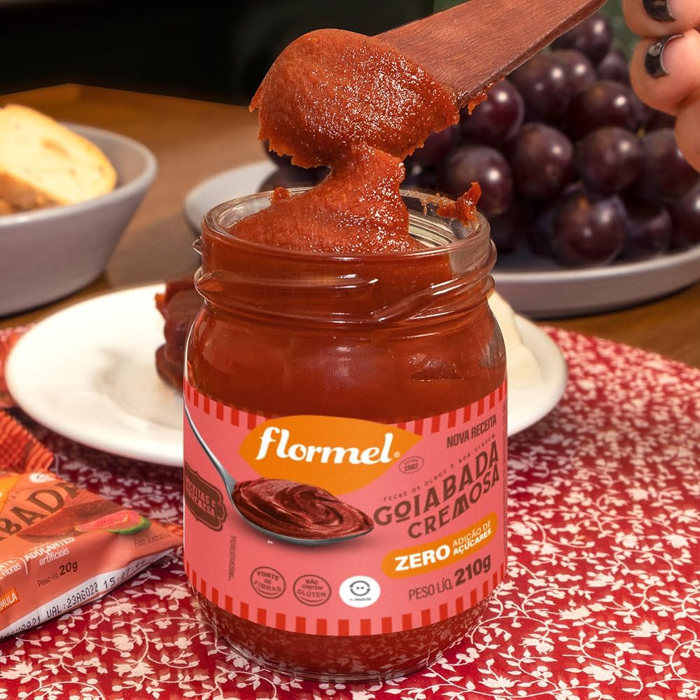 mesa de madeira com um padrão de toalha vermelha e elementos como frutas e um prato ao fundo.