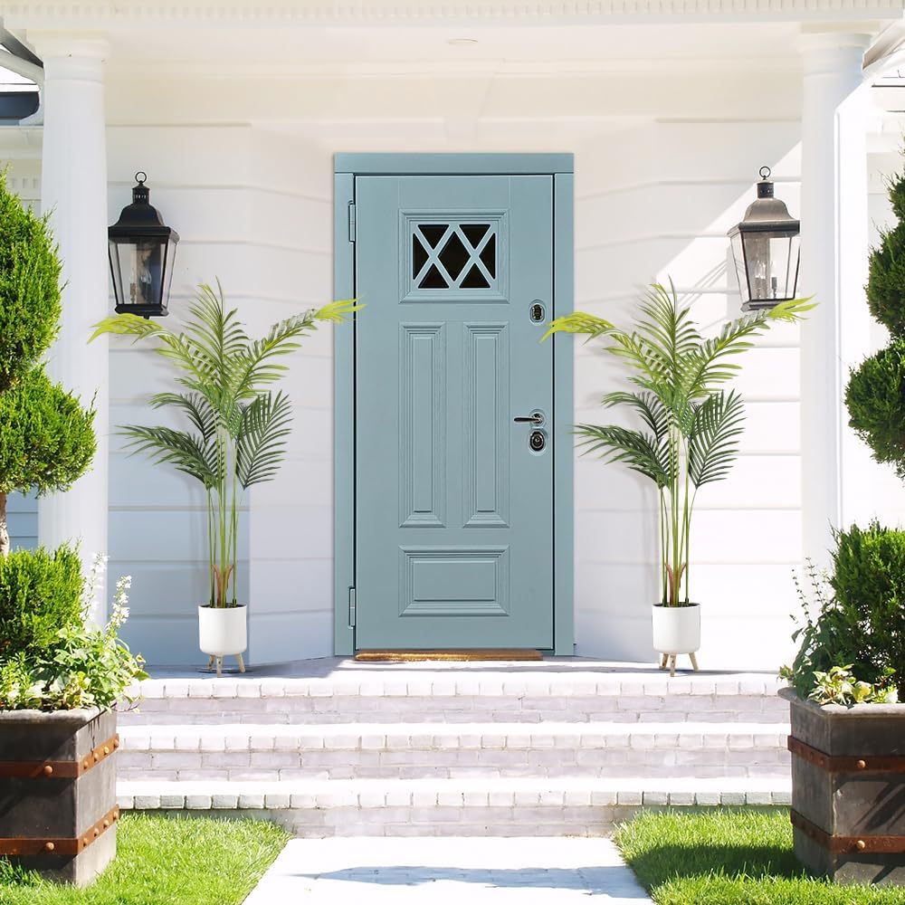 Imagem frontal de uma casa de madeira com fundo de gramado e escada de pedra.