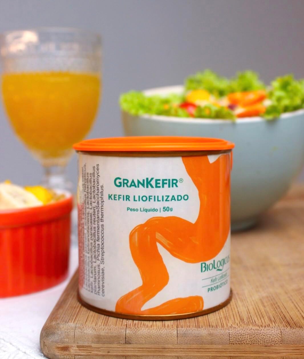 A tábua de madeira serve como base, com uma taça e uma tigela de salada ao fundo. A tábua de madeira serve como base, com uma taça e uma tigela de salada ao fundo.